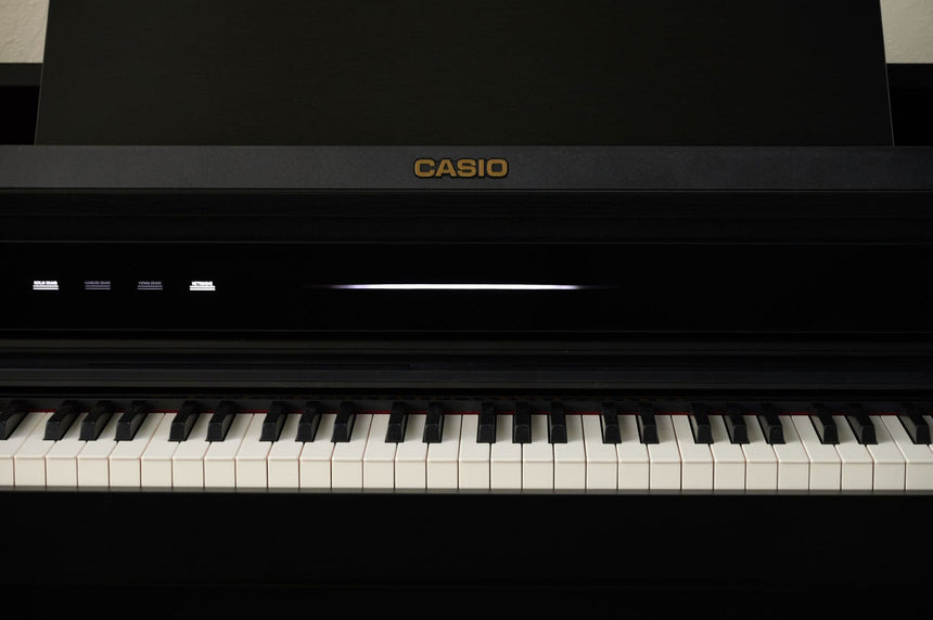 Casio AP-750BK digital piano in black – front detail with the keyboard cover open.