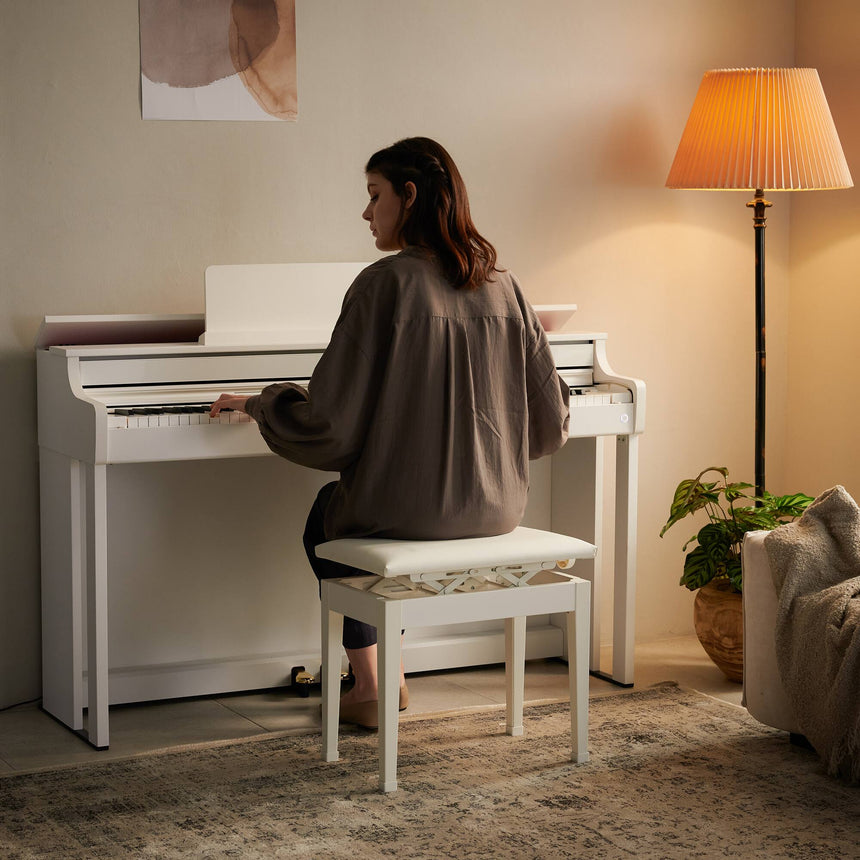 Casio AP-550WE digital piano in white – living-room scene with a pianist.