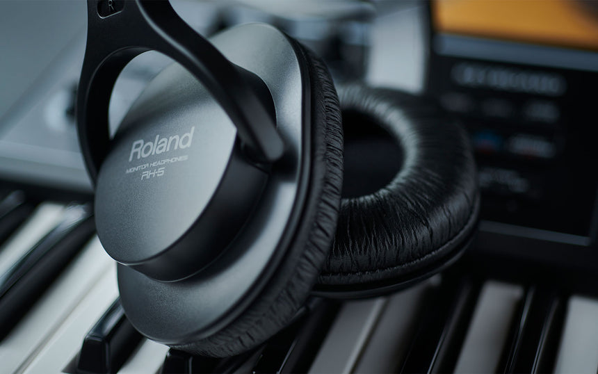 Casque Roland RH-5 noir, gros plan des écouteurs et coussinets sur des touches de piano